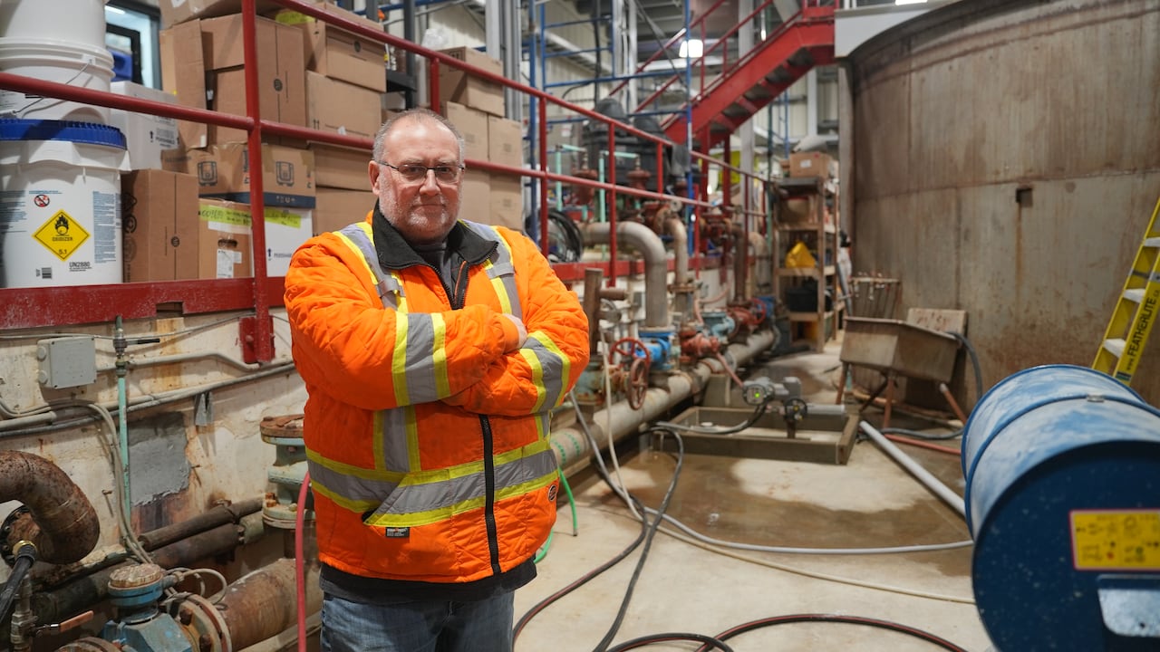 A man wearing a high visibility plant standing in an industrial building/