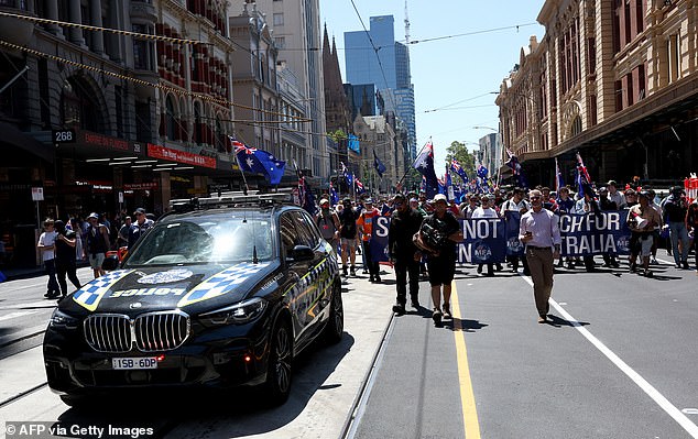 Anti-government protesters march along a road during a protest on Australia Day in Melbourne on January 26, 2026. (Photo by Izhar KHAN / AFP via Getty Images)
