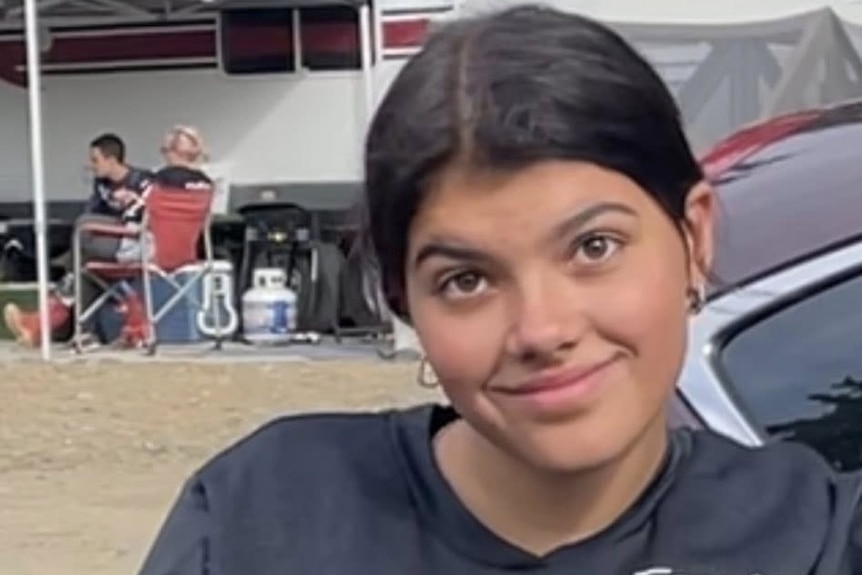 A young woman with dark hair sits on a motobike.
