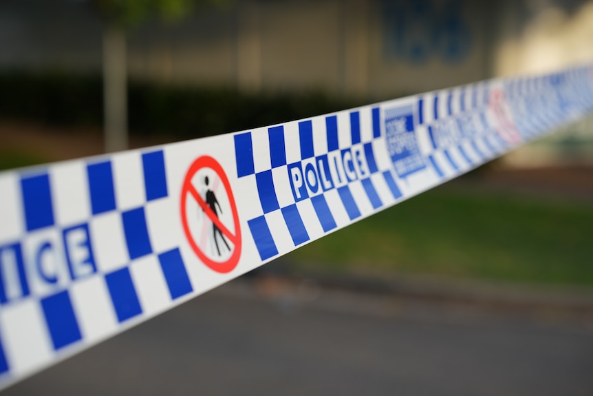 Images of blue and white checkered police tape stretched across a suburban street.