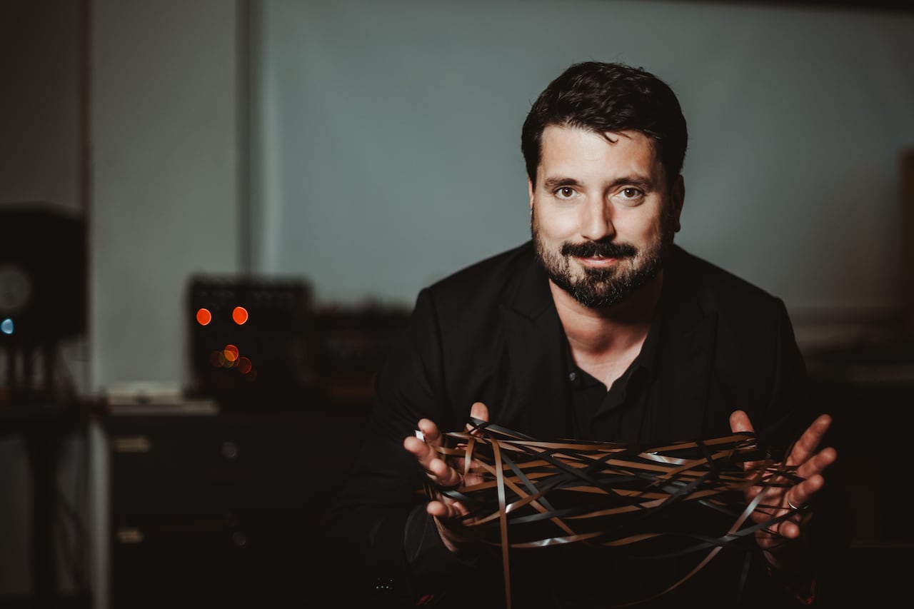 A man holding recording tape.