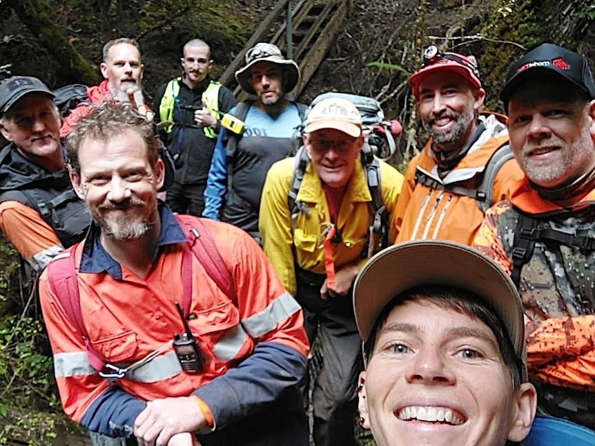 A group of people pose for a photo in bushland.