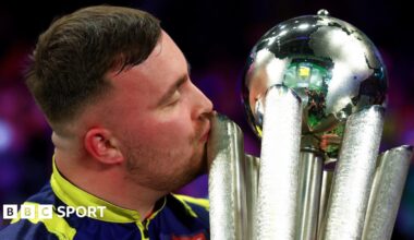 Luke Littler, with his eyes closed, kisses the World Championship trophy