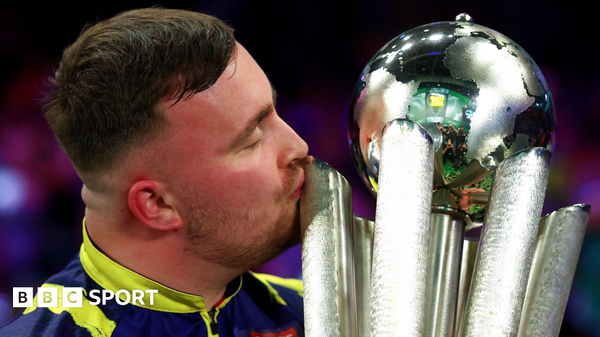 Luke Littler, with his eyes closed, kisses the World Championship trophy