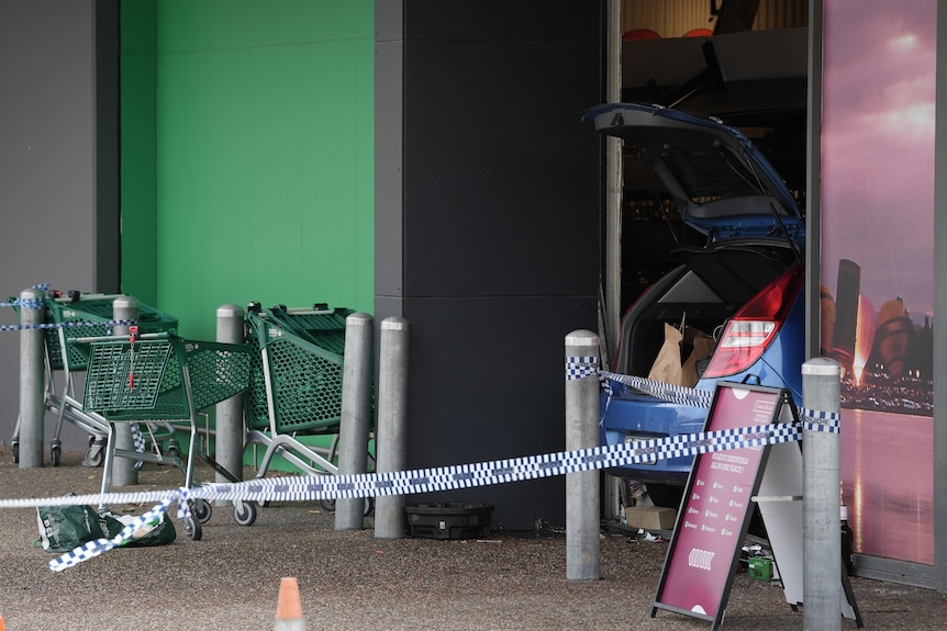 A car crashed into a shopping centre with police tape.