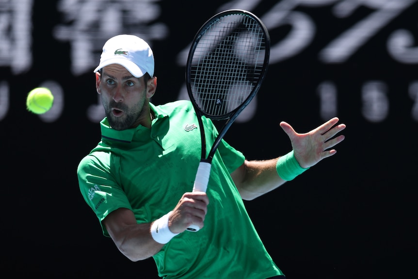 Novak Djokovic bends out of the way as he hits a backhand at the Australian Open.