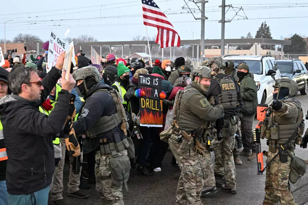 Protesters confront federal agents outside the Bishop Henry Whipple Federal Building, Thursday, Jan. 8, 2026, in Minneapolis, Minn. (AP Photo/Tom Baker)