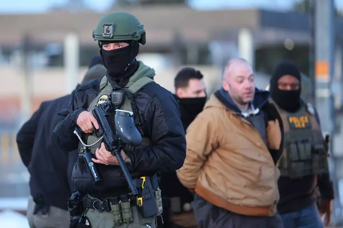 Protesters are arrested by federal agents outside the Bishop Henry Whipple Federal Building in Minneapolis, Friday, Jan. 9, 2026. (AP Photo/Adam Bettcher)
