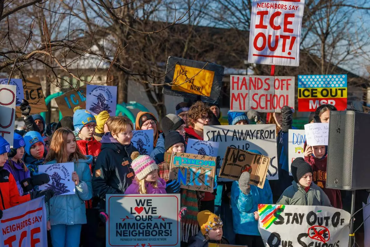 Minneapolis Public Schools families, educators and students hold signs during a news conference at Lake Hiawatha Park in Minneapolis, on Friday, Jan. 9, 2026, demanding Immigration and Customs Enforcement be kept out of schools and Minnesota following the killing of 37-year-old mother Renee Good by federal agents earlier on Wednesday. (Kerem Yücel/Minnesota Public Radio via AP)