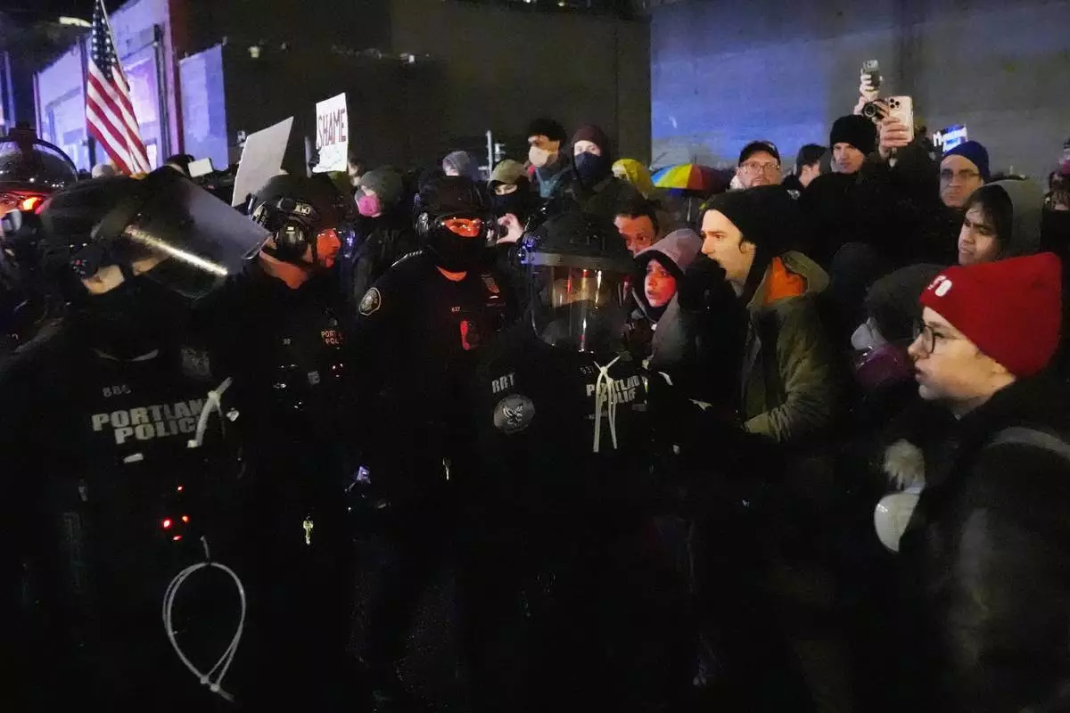 Protesters stand off against law enforcement outside the U.S. Immigration and Customs Enforcement facility in Portland, Ore., Thursday, Jan. 8, 2026. (AP Photo/Jenny Kane)