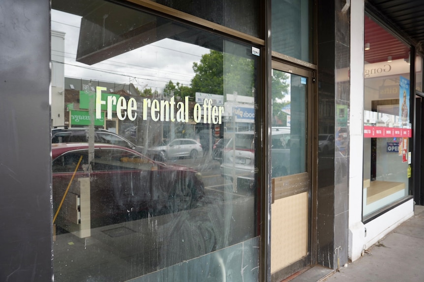 A sticker saying 'free rental offer' on a vacant shopfront in Victoria Street