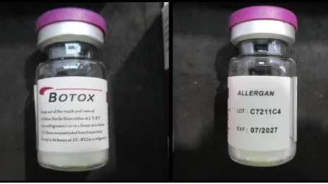A purple-capped clear vial of counterfeit Botox with a white label, seen on a black background next to branded packaging boxes