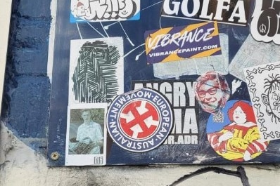 Stickers on a blue brick wall.