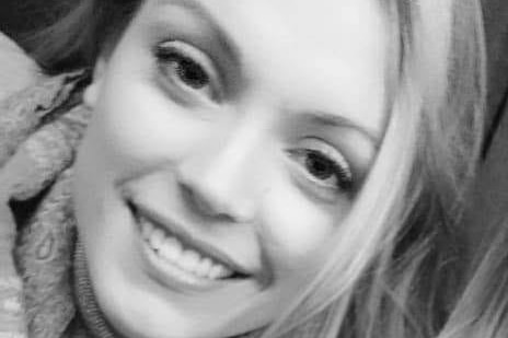 A young woman smiles at the camera.