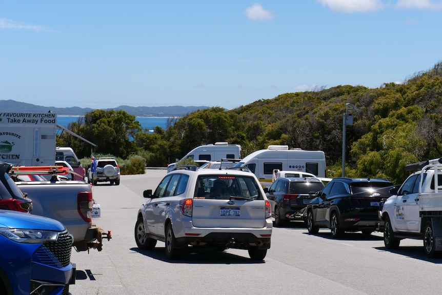 The Greens Pool car park with lots of cars and the ocean in the background