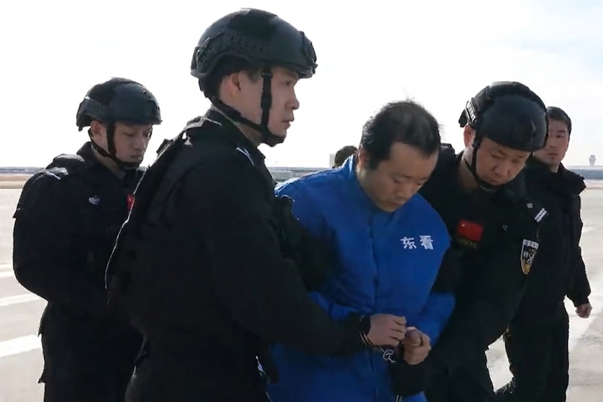 A still from a video showing Chen Zhi being escorted by guards. 