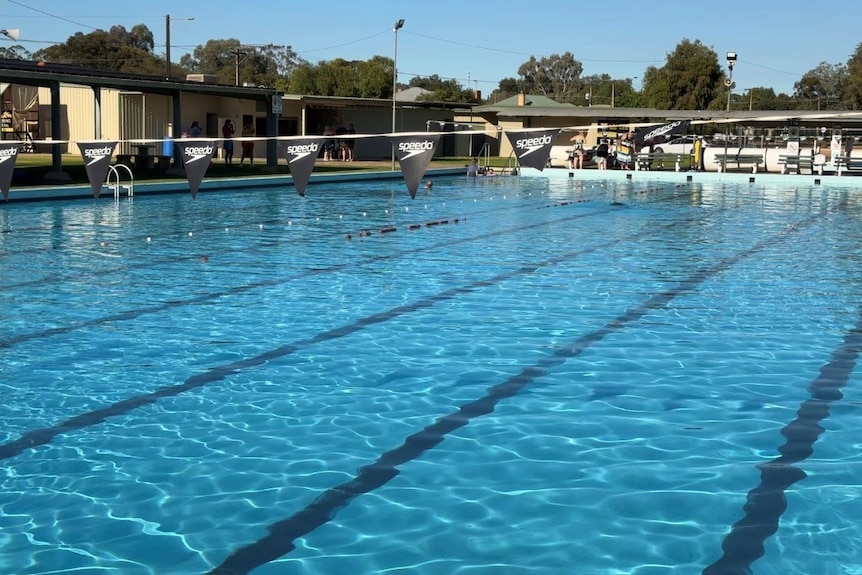 A mostly empty Olympic sized swimming pool.