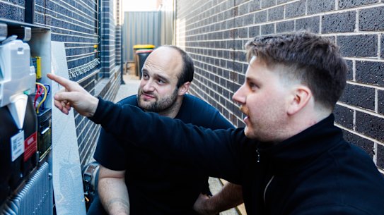 5/07/2025 Allan Lancaster pictured with Haidyn Boothey from 1KOMMA5° at his home in Truganina where he’s having a solar battery installed. Photo: Aaron Francis / The Age NEWS