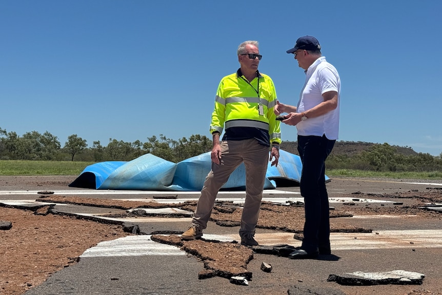 two men talking on broken concrete