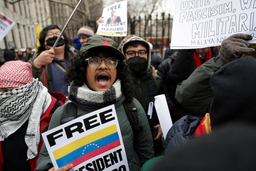 A young man holding a placard in support of Nicolas Maduro in a crowd in Manhattan.