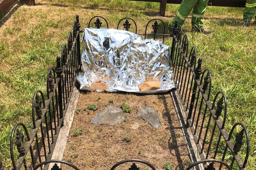 A small grave with a headstone wrapped in fire retardant material