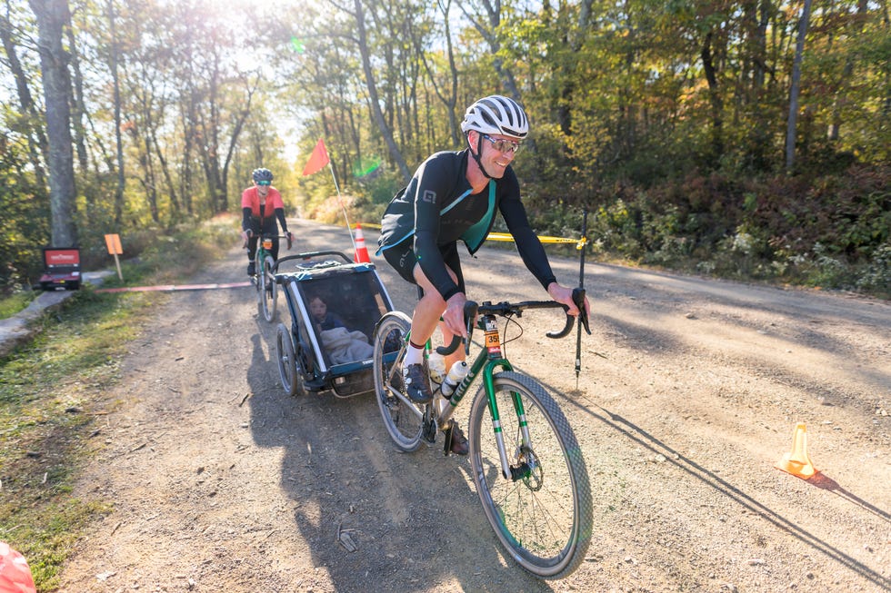 man riding a bike with a child in a trailer