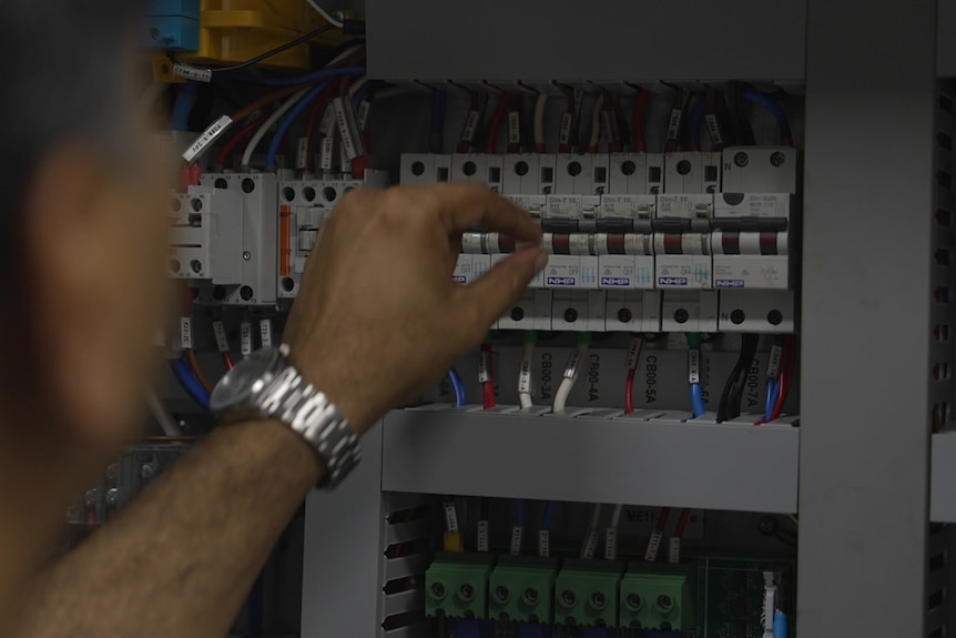 a man's hand seen flicking a switch