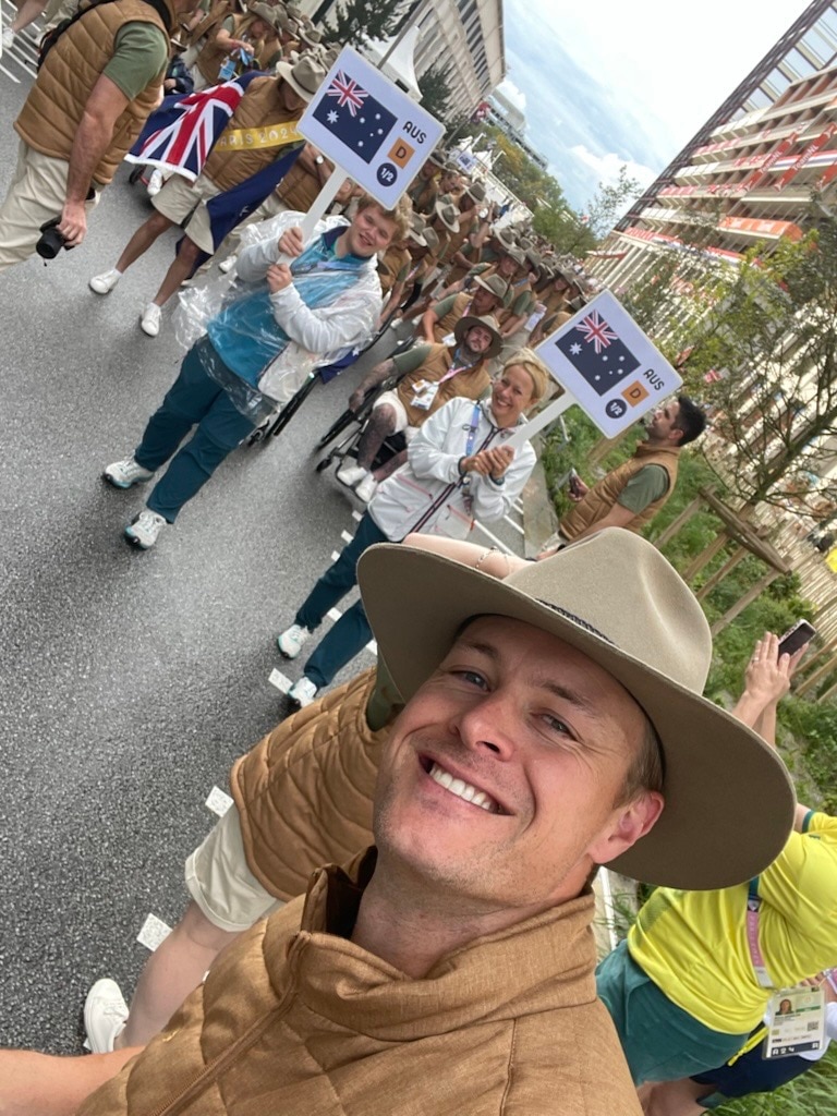 Curtis McGrath takes a selfie with team in the background.