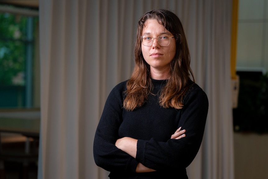 Anastasia Radievska looks at the camera with her arms folded