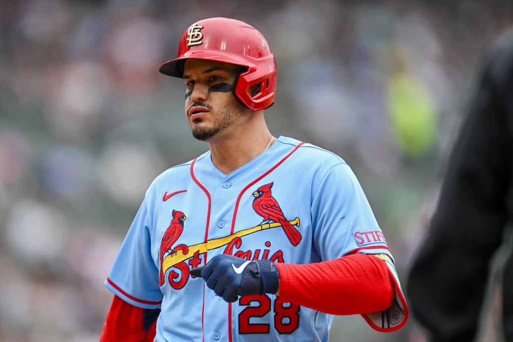 Nolan Arenado of the St. Louis Cardinals in a red helmet and blue jersey reacts on first base.