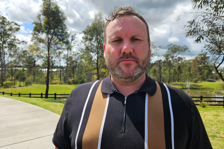 A profile photo of a man in a park. 