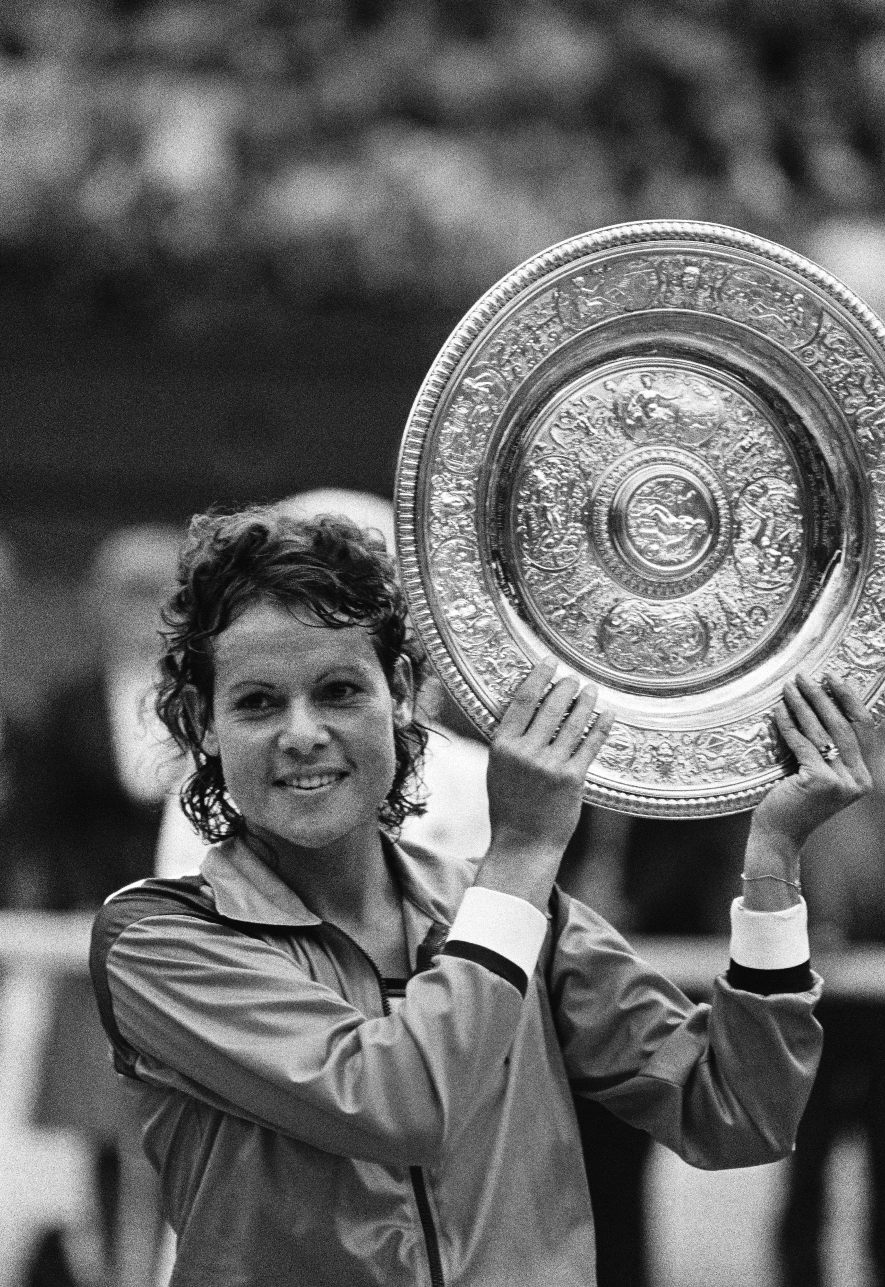 Evonne holds up the Wimbledon trophy.