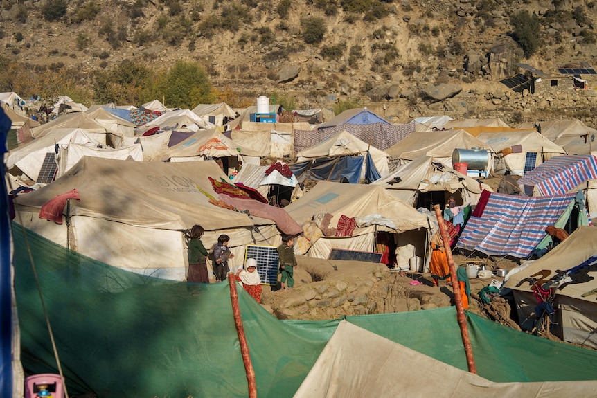 A line of tents sit nestled beside a mountain in Afghanistan.