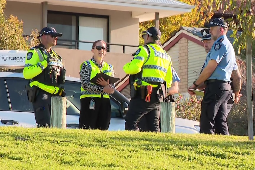 Police stand around a suburban park chatting