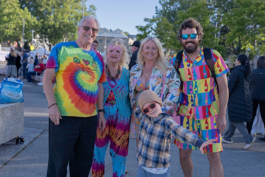 A family in colourful clothing smiling at the camera