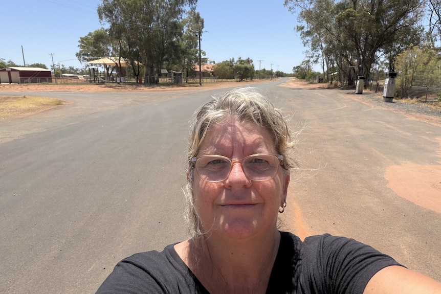 Woman standing in the middle of street in outback NSW.