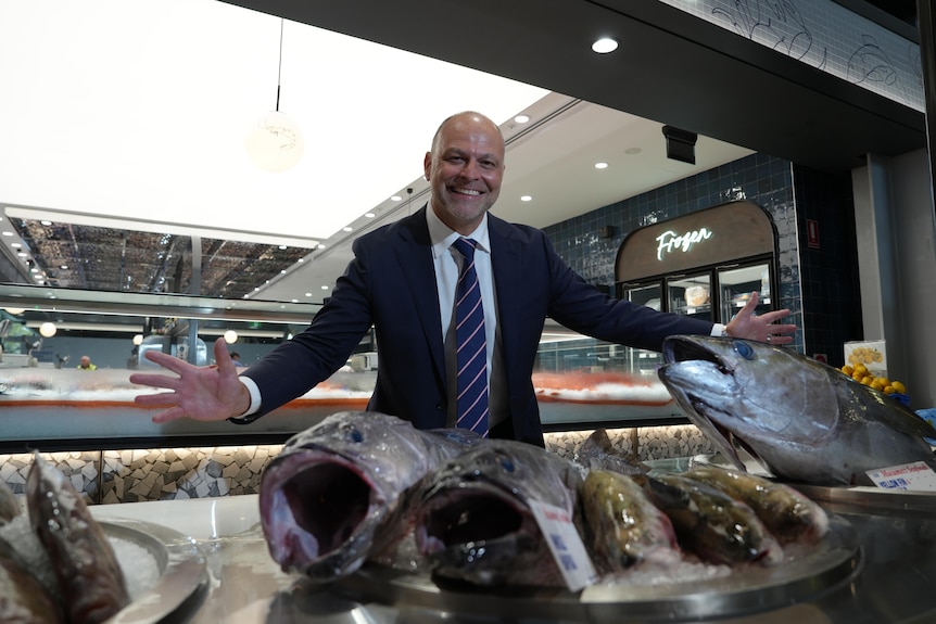 Man with arms open and fish in the foreground