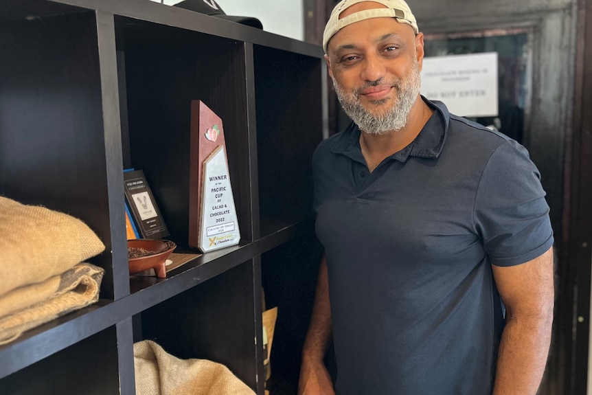 man having a photo taken in front of an award 