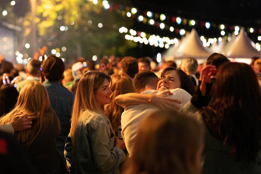People gathering at a big colourful music and food festival.