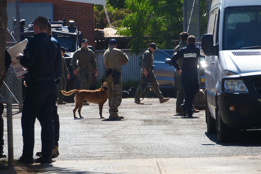 Police in uniform with a dog.