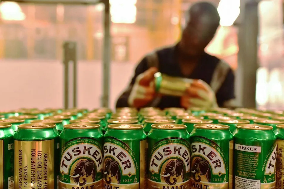 An employee of the East African Breweries Limited sorts Tusker beer cans in 2019 at the company's plant in Ruaraka, Kenya.