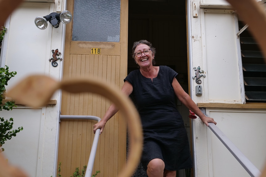 lady smiling on front steps of house