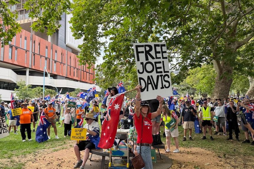 A woman holding a Free Joel Davis sign