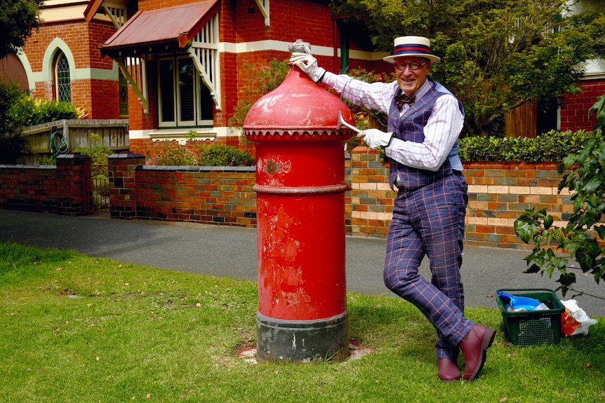 Mick Slocum stands next to a historic Australia Post pillar box