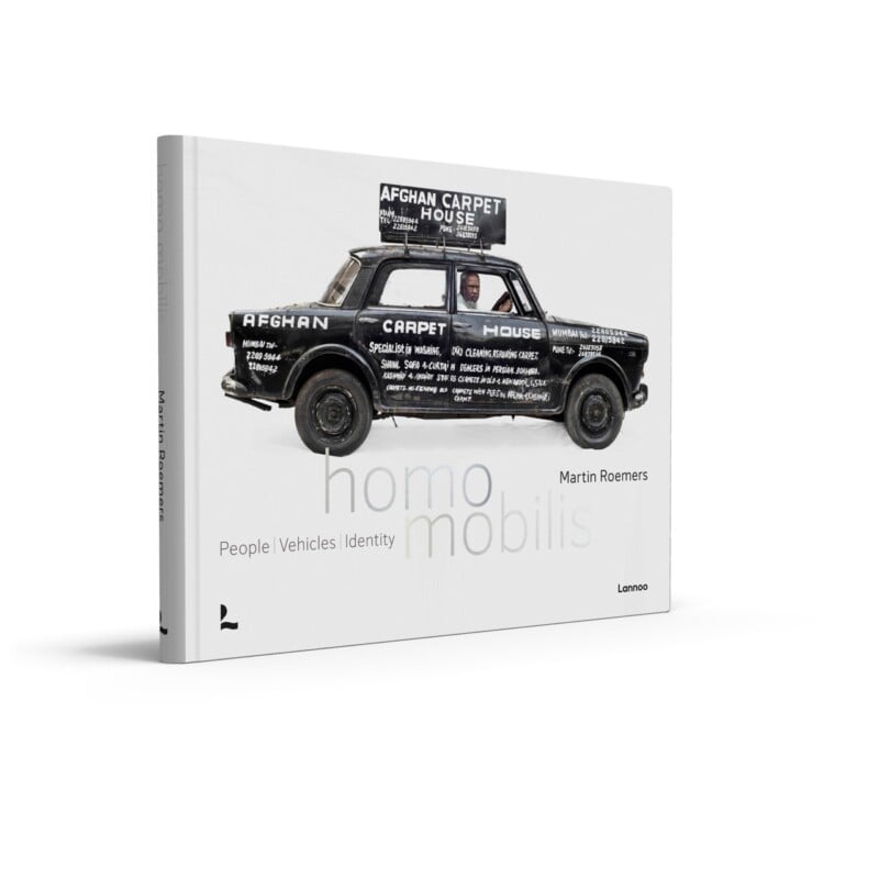 Book cover for "homo mobilis" by Martin Roemers, featuring a car covered in black paint and white text advertising "Afghan Carpet House," with the themes: People, Vehicles, Identity.