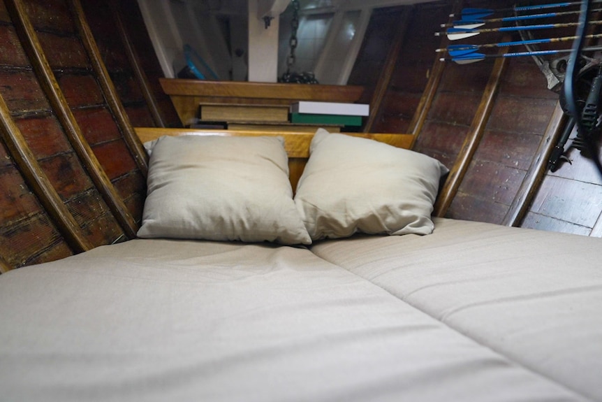 A photo of pillows on a bed inside a small yacht