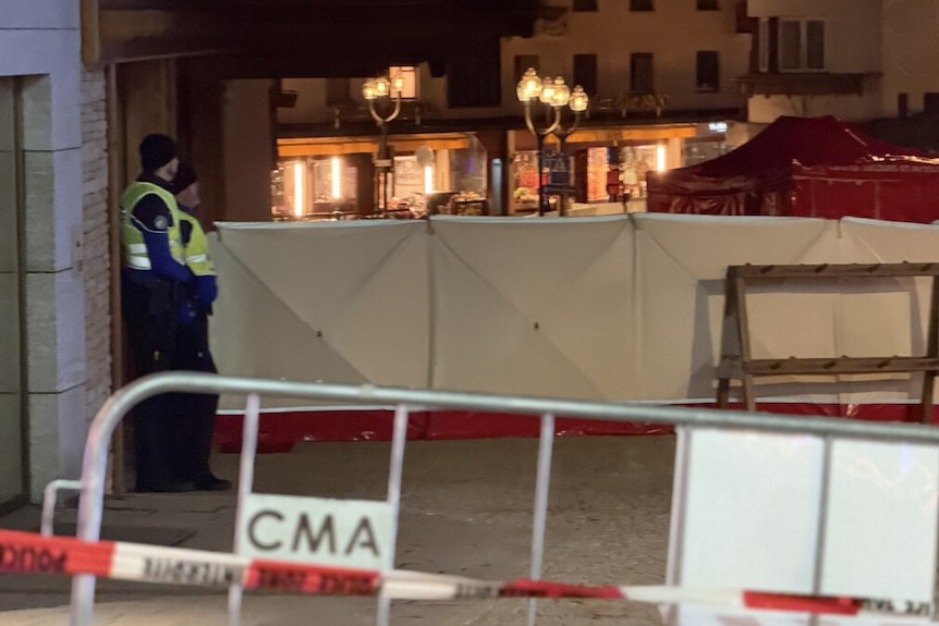 Police stand guard near the scene of a blaze at a Swiss resort.