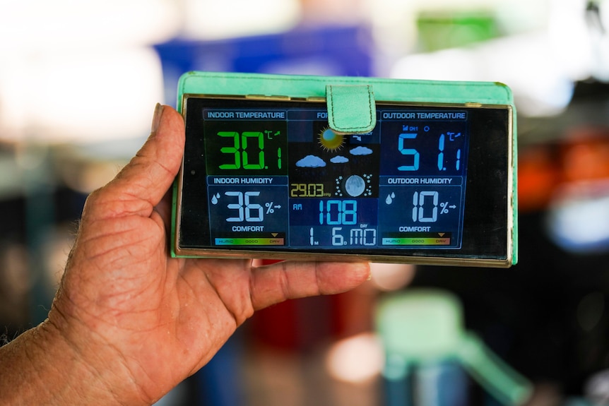 A mobile phone shows the temperature and other weather numbers