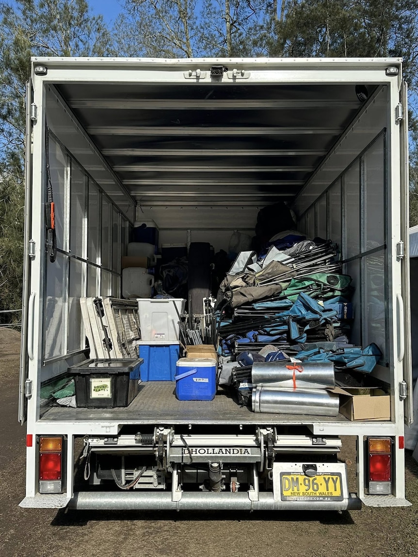 the back of a removalist truck fille with camping gear and tents