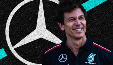 Toto Wolff smiling with a Mercedes logo black, white and turquoise background